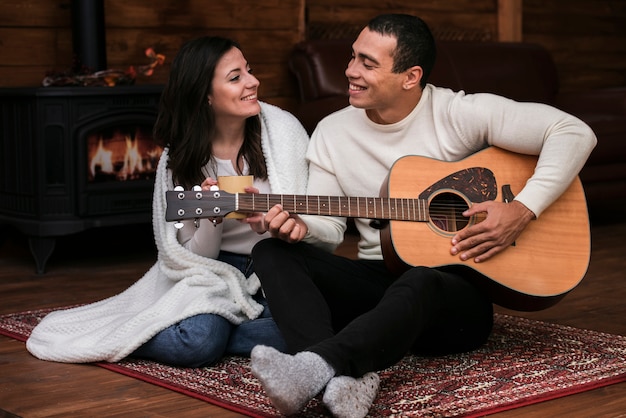 Foto gratuita joven tocando la guitarra para mujer