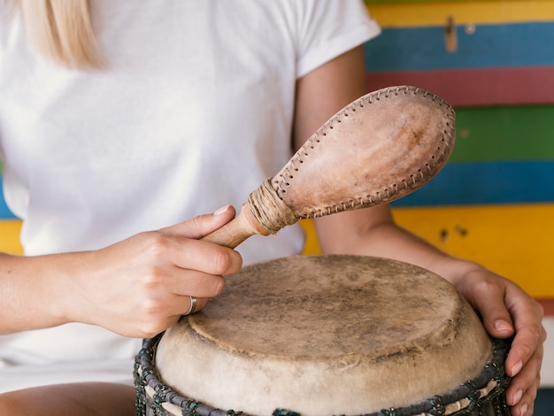 Joven tocando instrumentos de percusión cerca de la pared multicolor