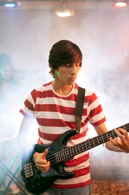 Joven tocando música de guitarra en un evento local