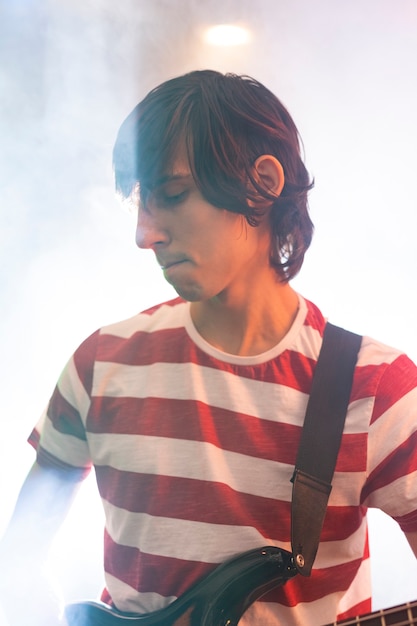 Joven tocando música de guitarra en un evento local