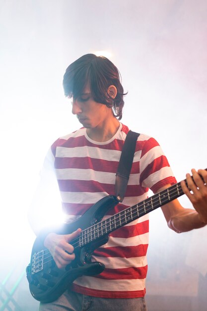 Joven tocando música de guitarra en un evento local