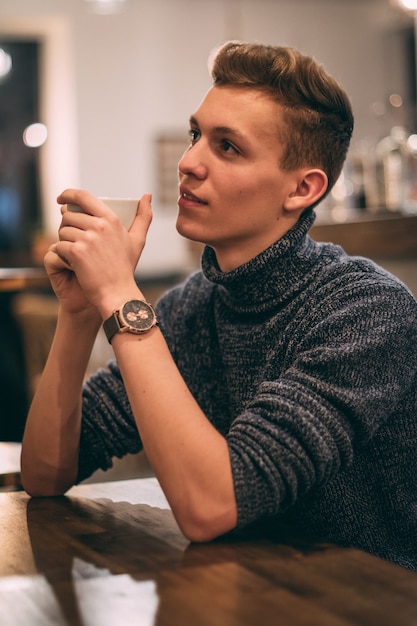 Foto gratuita joven tomando café en la cafetería