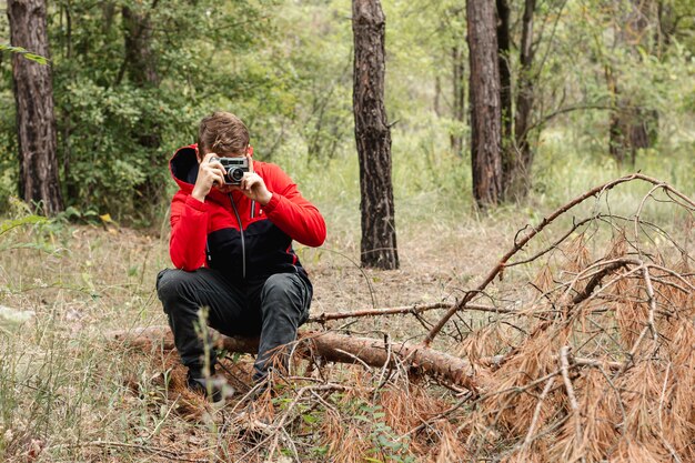 Joven tomando fotos en el bosque con espacio de copia