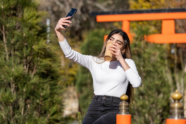 Joven tomando selfie con su café Foto de alta calidad