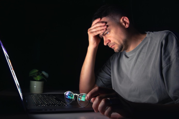 Foto gratuito el joven trabaja en la computadora por la noche.