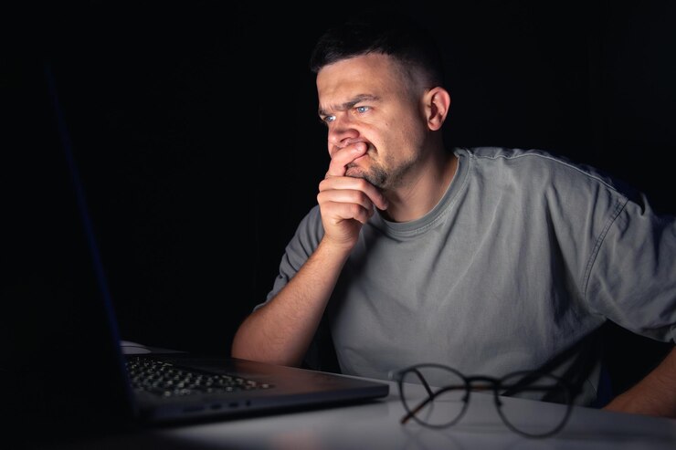 Foto gratuito el joven trabaja en la computadora por la noche.