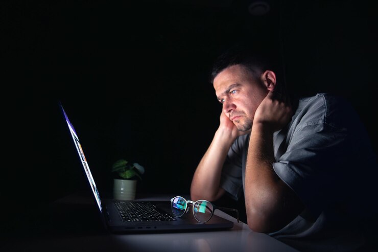 Foto gratuito el joven trabaja en la computadora por la noche.