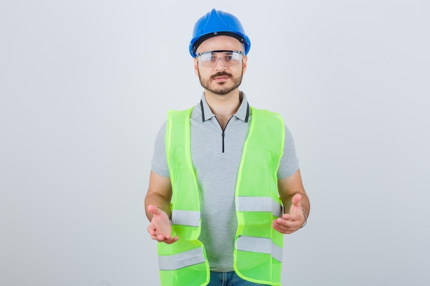 Joven trabajador de la construcción en un casco de seguridad y gafas