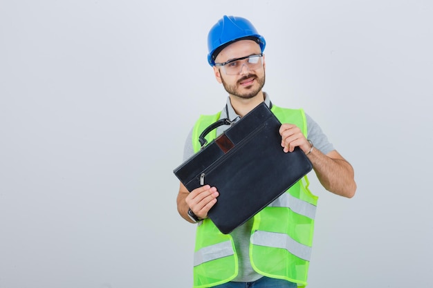 Joven trabajador de la construcción con casco de seguridad y gafas