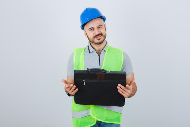 Joven trabajador de la construcción en un casco de seguridad y gafas