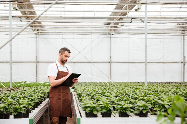 Joven trabajador haciendo investigación con plantas