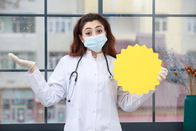 Joven trabajador de la salud con mascarilla sosteniendo una burbuja de ideas y no sabe qué hacer Foto de alta calidad