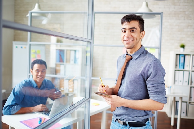 Joven trabajador sujetando una libreta