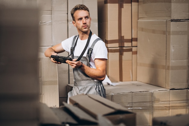 Joven trabajando en un almacén con cajas