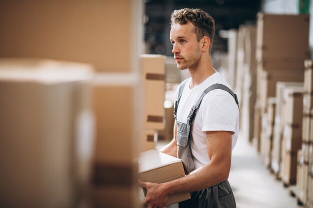 Joven trabajando en un almacén con cajas