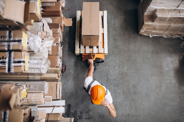 Joven trabajando en un almacén con cajas