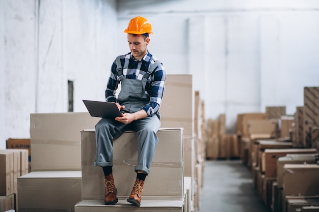 Foto gratuita joven trabajando en un almacén con cajas