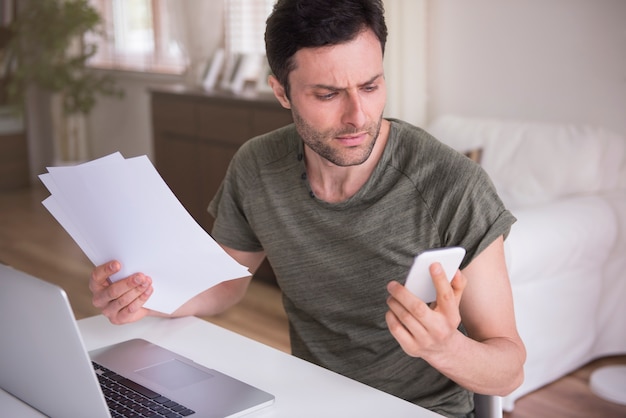 Foto gratuita joven trabajando en casa con su computadora portátil