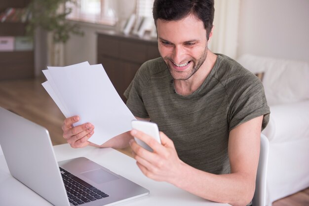 Joven trabajando en casa con su computadora portátil