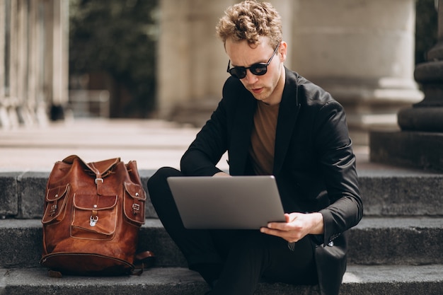 Joven trabajando en una computadora por la universidad