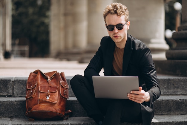 Joven trabajando en una computadora por la universidad