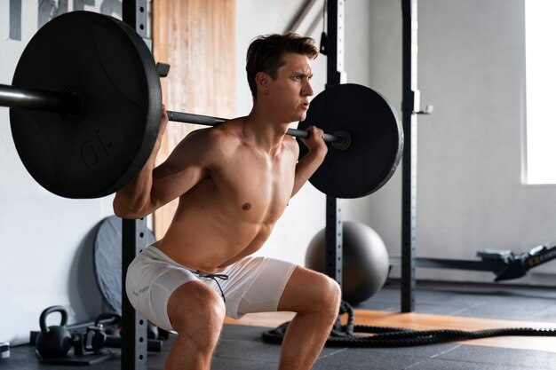 Joven trabajando en el gimnasio para culturismo