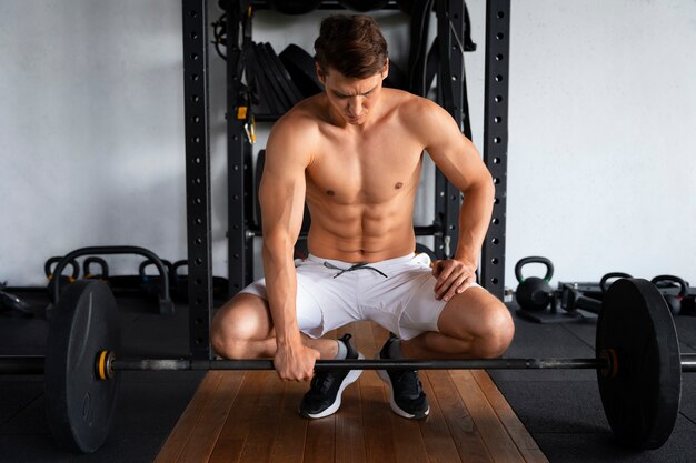 Joven trabajando en el gimnasio para culturismo