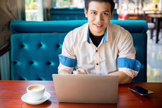 Joven trabajando con laptop en cafe