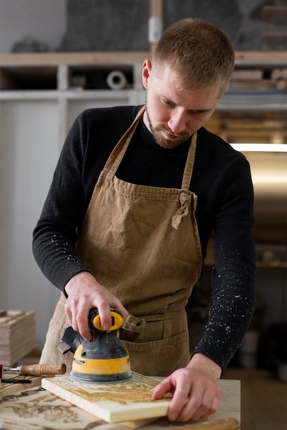 Foto gratuita joven trabajando en un taller de grabado en madera