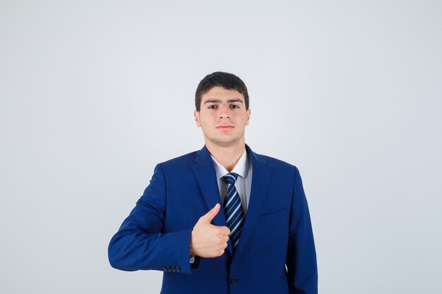 Joven en traje azul formal mostrando el pulgar hacia arriba