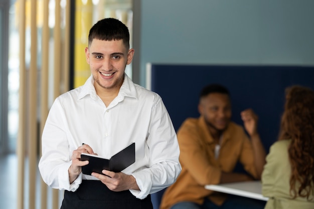 Joven trans con delantal trabajando como camarero