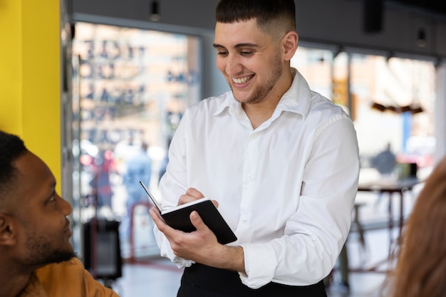 Joven trans con delantal trabajando como camarero