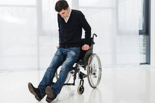 Joven tratando de llegar desde la silla de ruedas