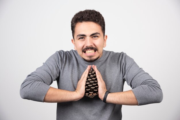 Un joven tratando de romper una gran piña.