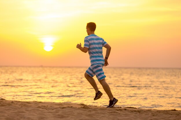 Joven trotar en la costa del mar