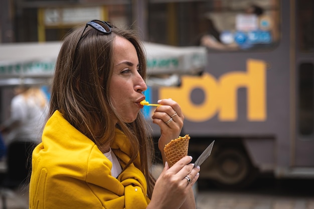Una joven turista come helado en un paseo por la ciudad