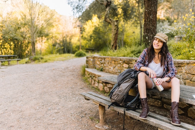 Joven turista descansando con termo