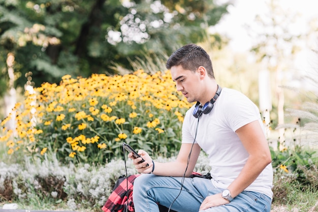 Foto gratuita joven usando teléfono inteligente