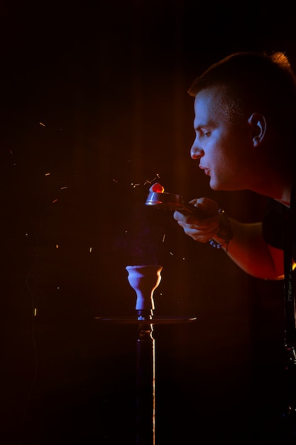 Joven vaping de una pipa de agua en un bar.