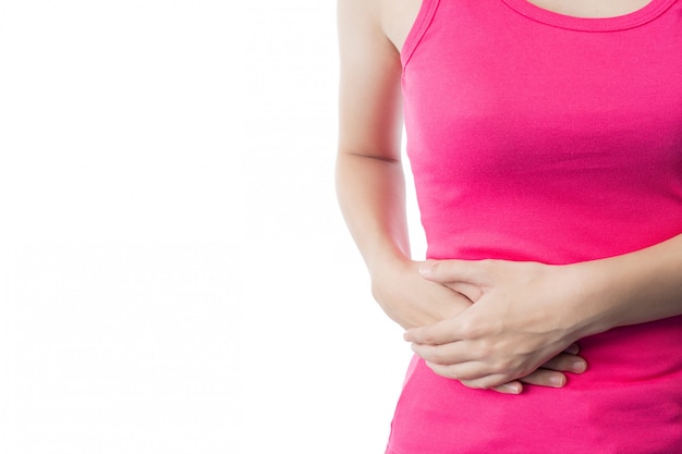 La joven vestida con una camisa rosa sufre de dolor abdominal.