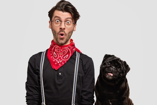 Foto gratuita joven vestido con pañuelo rojo y camisa negra y su perro