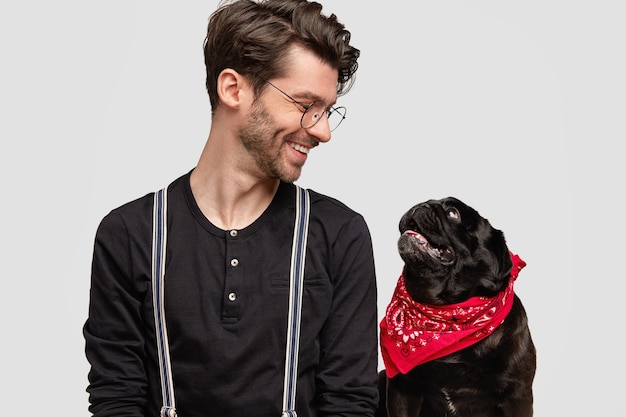 Joven vestido con pañuelo rojo y camisa negra y su perro