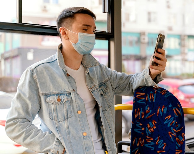 Joven viajando en autobús urbano con smartphone