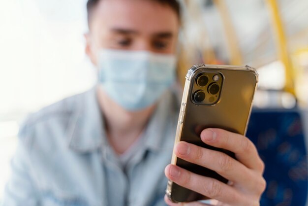 Joven viajando en autobús urbano con smartphone