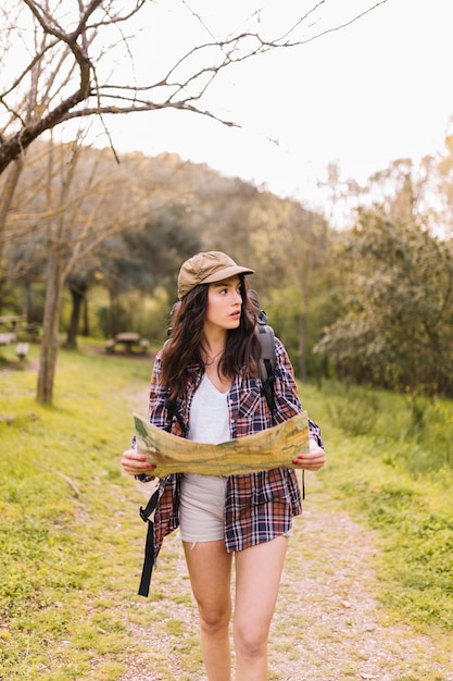 Foto gratuita joven viajero caminando con mapa