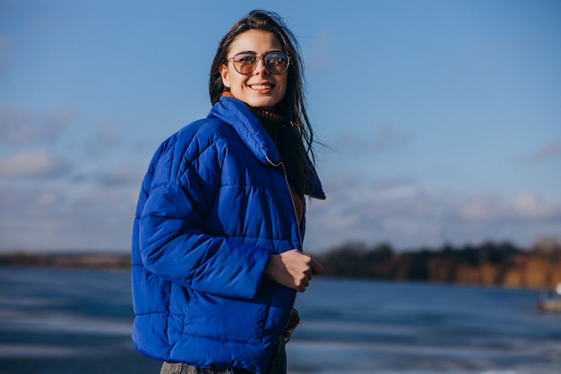 Joven viajero en chaqueta azul en la playa