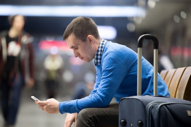 Joven viajero esperando en el aeropuerto