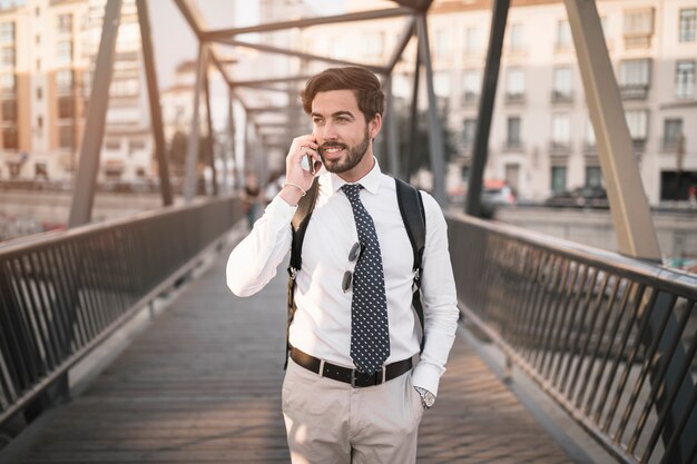 Joven viajero masculino hablando por teléfono celular