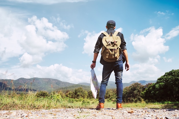 Joven viajero con mochila relajante al aire libre.