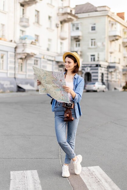 Joven viajero con sombrero revisando el mapa